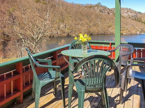 una mesa y sillas en una terraza con vistas al río en 5 person holiday home in lyngdal, en Korshamn