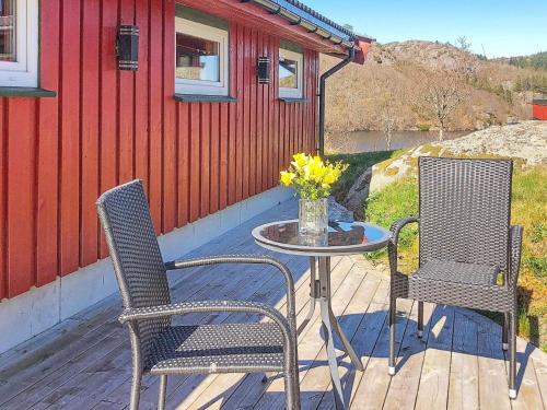 two chairs and a table on a deck at 5 person holiday home in lyngdal in Korshamn