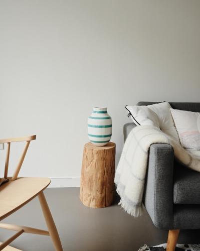 a living room with a couch and a vase on a table at Hygge Kro in Hualien City