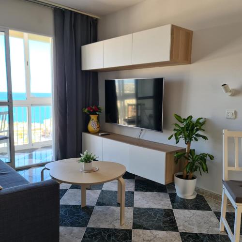 een woonkamer met een tv en een bank en een tafel bij Torremolinos holiday Sun & Sea in Torremolinos