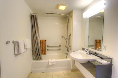 a white bathroom with a sink and a shower at Howard Johnson by Wyndham Harrisonburg in Harrisonburg