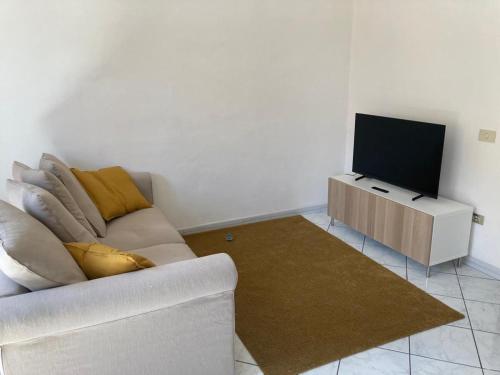 een woonkamer met een witte bank en een flatscreen-tv bij Casa di Abe in Florence