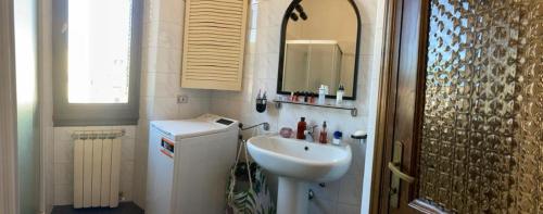 uma casa de banho com um lavatório, um espelho e um lavatório branco em Casa di Abe em Florença