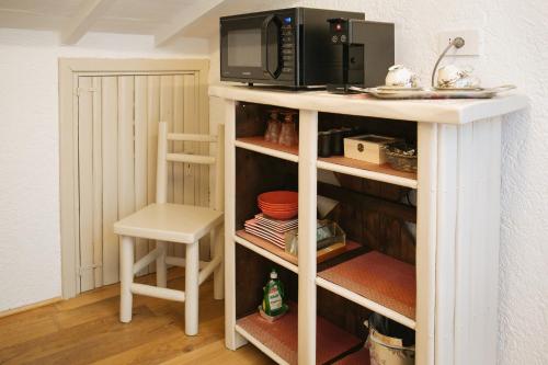 a microwave sitting on top of a white shelf at Domus Socolatae Residenza d'Epoca Charming B&B - Adults Only in Follonica