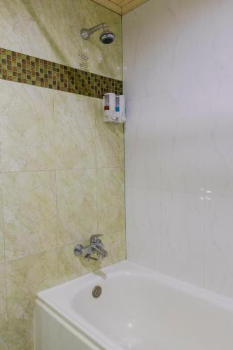 a bathroom with a shower and a tub and a sink at Pinnacle Lumpinee Park Hotel in Bangkok
