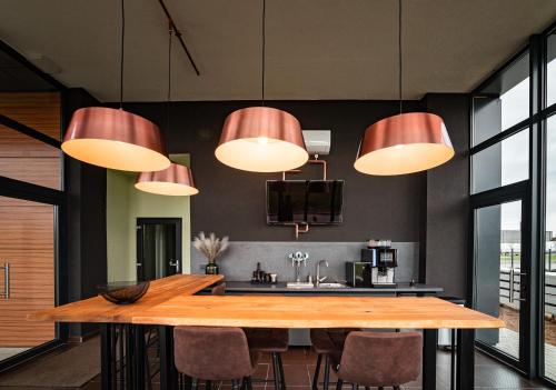 Mustang Boutique Rooms في أوراديا: مطبخ مع طاولة خشبية كبيرة وأضواء