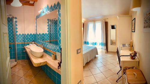 La salle de bains est pourvue d'un lavabo et d'un miroir. dans l'établissement B&b Domo La Laguna, à Cabras