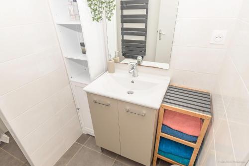 uma casa de banho com um lavatório e um espelho em LES 7 ÎLES em Baden