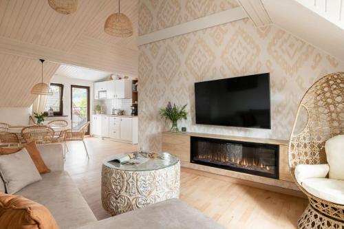 Il comprend un salon avec une cheminée et une télévision. dans l'établissement Apart-Center Motola Residence, à Zakopane