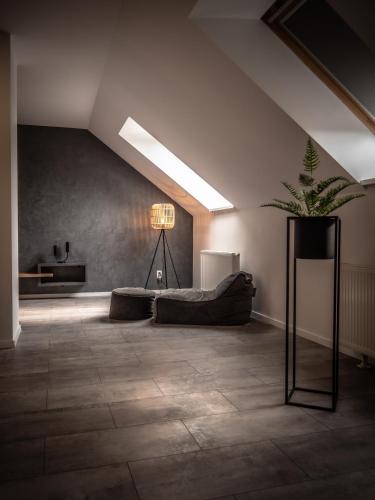 a living room with a couch and a potted plant at Hotel Novy Kastiel - Self check-in in Topoľčany