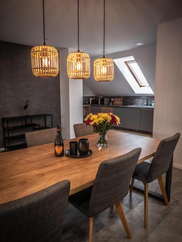 a dining room with a wooden table with chairs and lights at Hotel Novy Kastiel - Self check-in in Topoľčany