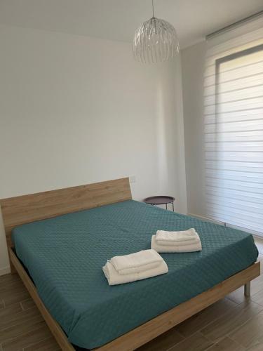 1 dormitorio con 1 cama con 2 toallas en Residenza Tramontana, en Elmas