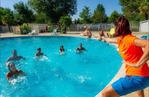 een groep mensen die in een zwembad spelen bij MOBIL HOME 3 Chambres Climatisé au CAMPING DES ISCLES in La Roque-dʼAnthéron
