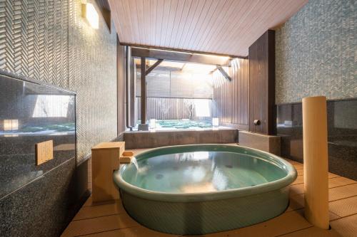 a bathroom with a large tub in a room at Kyoto Umekoji Kadensho in Kyoto