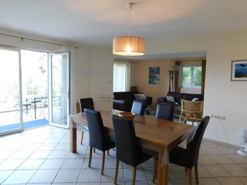 - une salle à manger et un salon avec une table et des chaises en bois dans l'établissement Villa 54 - Plage Aiguebelle 250m, au Lavandou