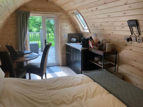 a bedroom with a bed and a desk and a kitchen at Scallow Campsite in Lewes