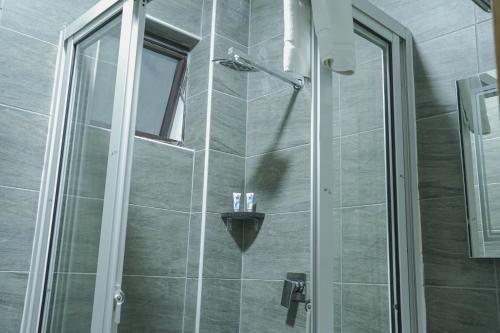 a bathroom with a shower with a glass door at Hotel Comster Mtwapa in Mtwapa