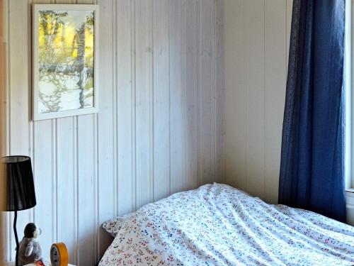 a bedroom with a bed with a blue comforter at 5 person holiday home in LAUPSTAD in Vestpollen