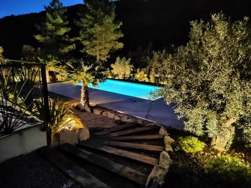 - une piscine dans un jardin la nuit dans l'établissement Villa les trois J, à Grimaud
