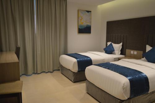 a hotel room with two beds with blue pillows at Terrace View Serviced Apartments 2 in Al Khobar