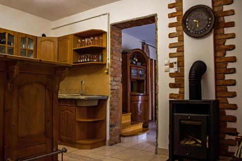 a kitchen with a fireplace and a clock on the wall at Egri Leányka Vendégház in Eger