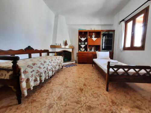 a bedroom with two beds and a fireplace at Maria's Village Home in Glinado Naxos