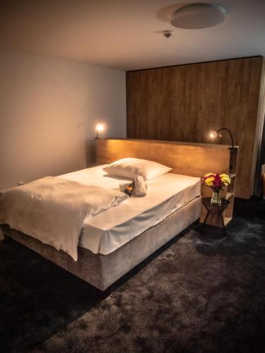 a bedroom with a large bed with white sheets at Hotel Novy Kastiel - Self check-in in Topoľčany