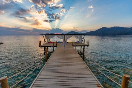a person walking on a dock in the water at Liberty Lykia Adults Only in Oludeniz