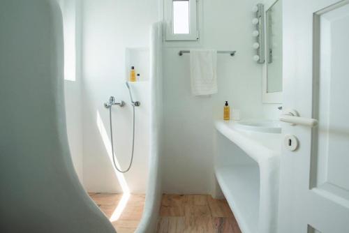 a white bathroom with a shower and a sink at Villa Ruby by Mykonos Rocks in Mikonos