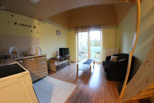 a kitchen and a living room with a stairway at Apartamenty Green Garden in Racibórz