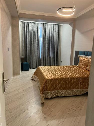 a bedroom with a bed and a large window at Levent Beach Apartment in Sumqayıt