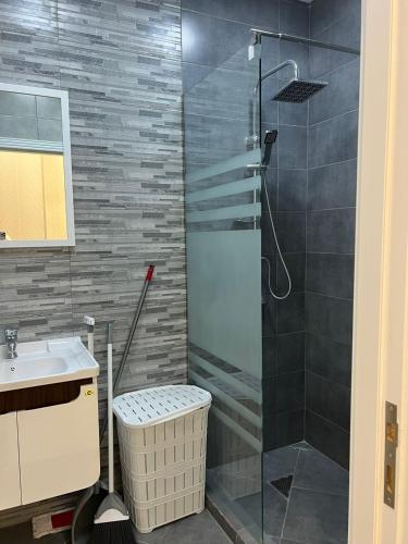 a bathroom with a shower and a sink at Levent Beach Apartment in Sumqayıt