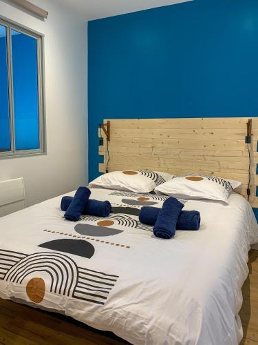- un grand lit avec 2 oreillers bleus dans l'établissement Ambiance Cosy, à Buxy