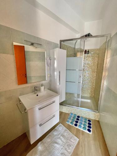 a bathroom with a white sink and a shower at La Fresia Bianca in Sciacca