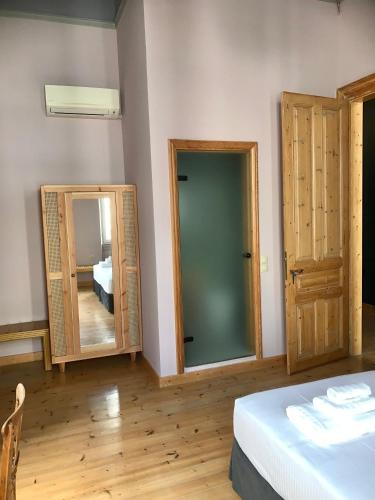 a room with two mirrors and a bed and a bedroom at VASILIKON Hotel 1888 the past is present HISTORICAL PRESERVATION MONUMENT in Kalamata