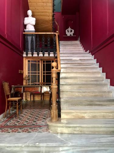 a set of stairs in a room with a piano at VASILIKON Hotel 1888 the past is present HISTORICAL PRESERVATION MONUMENT in Kalamata