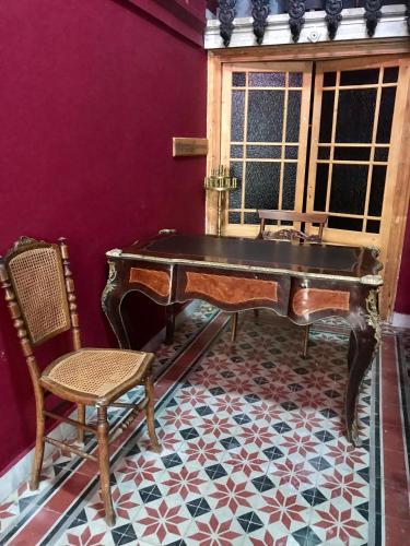 an old piano and a chair in a room at VASILIKON Hotel 1888 the past is present HISTORICAL PRESERVATION MONUMENT in Kalamata