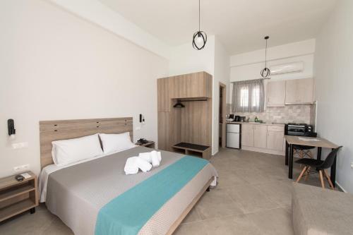 a bedroom with a large bed and a kitchen at Loggos Apartments in Lóngos