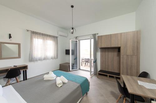 a bedroom with a bed and a desk and a table at Loggos Apartments in Lóngos