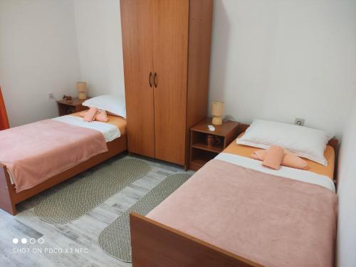 twee bedden in een kleine kamer met bij Apartmani Lana in Šibenik