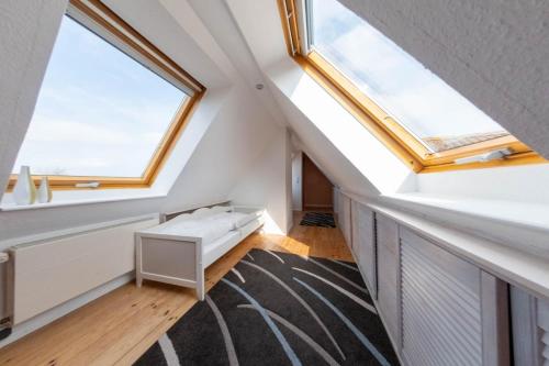 a attic room with a skylight and a rug at Gold Fehmarn in Fehmarn