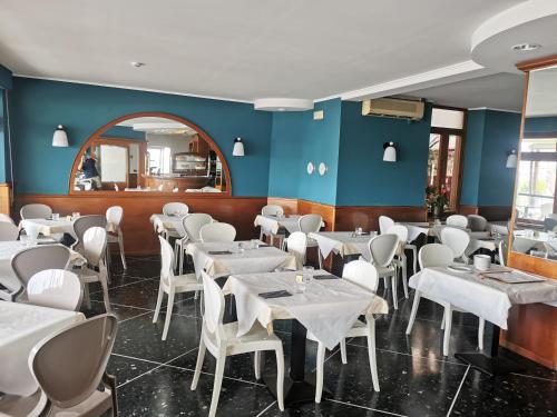 a dining room with white tables and chairs at Albium - Hotel Sul Mare in Albenga