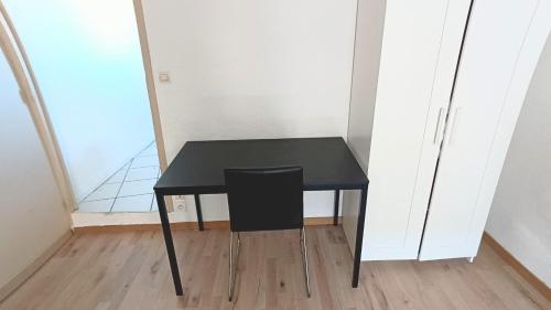 - une table noire avec une chaise noire dans la chambre dans l'établissement Narbonne Studio renové centre ville, à Narbonne