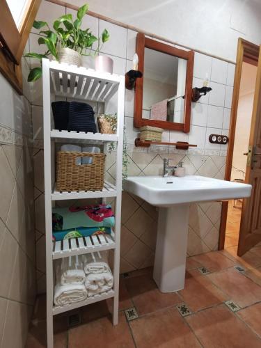 a bathroom with a sink and a shelf with towels at CASA JOAN in Elche