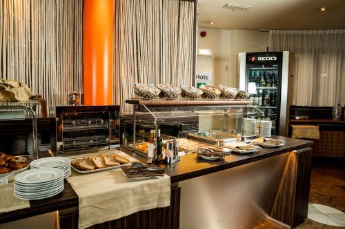 a bakery with a counter with bread and pastries at Hotel Pineta in Busto Arsizio