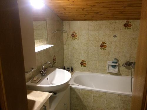 a bathroom with a white tub and a sink at Haus Seeberghof by Globalimmoservice in Millstatt