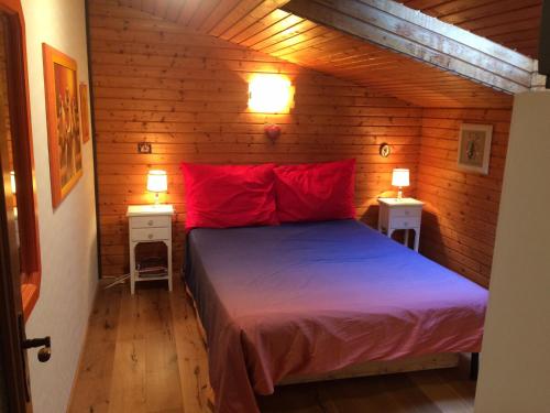 a bedroom with a bed with red pillows and two tables at Haus Seeberghof by Globalimmoservice in Millstatt