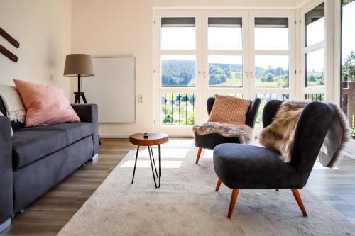 a living room with a couch and chairs and a table at Sonnen Panorama - Abenteurer und Weltentdecker in Winterberg