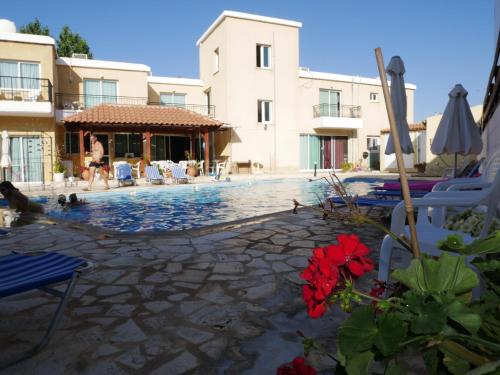 a swimming pool in front of a building at Kozis Hotel Apartments in Polis Chrysochous