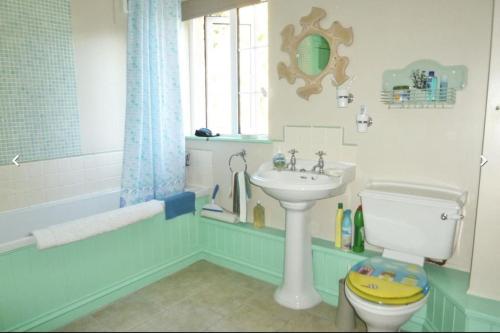 a bathroom with a sink and a toilet and a tub at Lovely Cornish cottage in small village setting in Saint Hilary